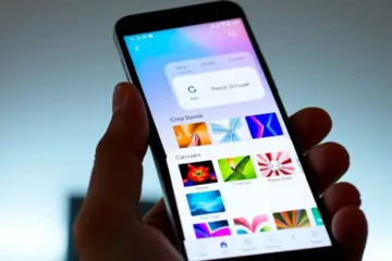 alt_text: A hand holding a smartphone showing a customizable IPTV app interface with multiple skin options in a preview carousel.