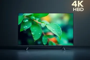 alt_text: A sleek TV displays a vibrant 4K nature documentary with water droplets on leaves in a dark studio.