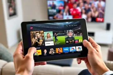 alt_text: A person holds a tablet displaying a vibrant IPTV app with live sports, set in a modern, softly lit living room.